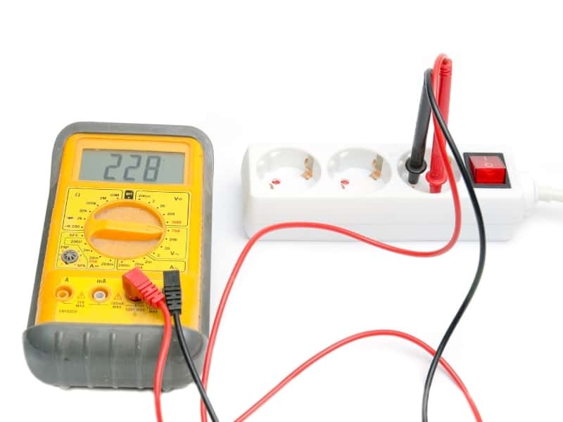 Voltage meter checking AC volts white background