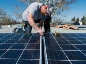 Man installing solar panels connecting two panels