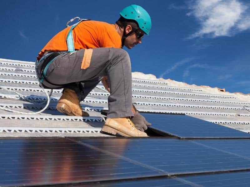 Man on a roof installing solar panels